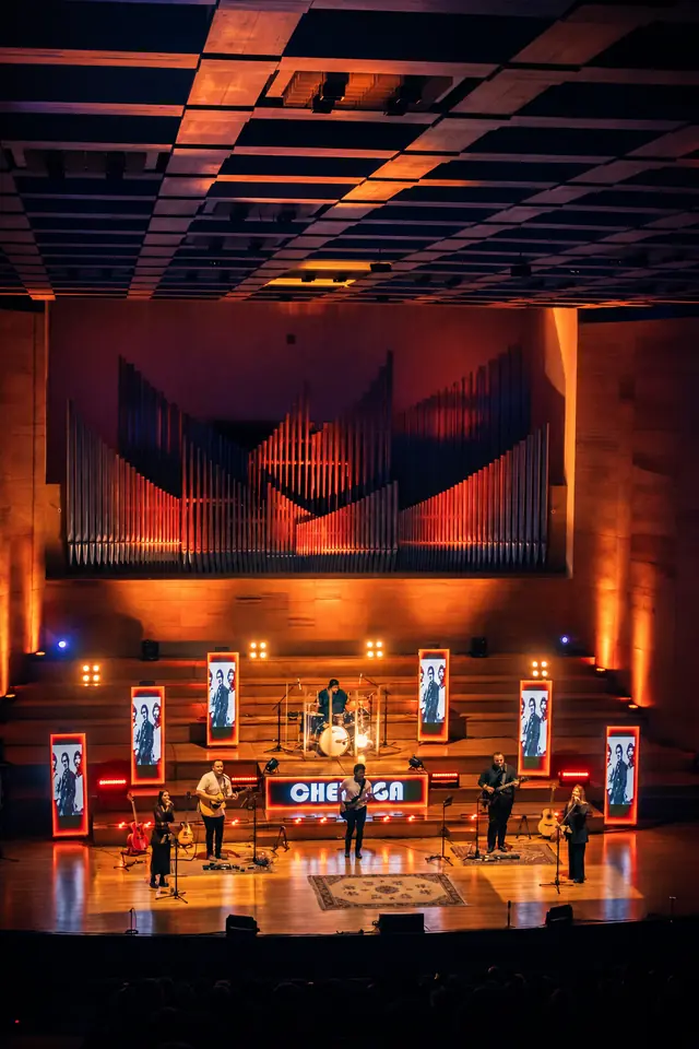 Cheroga en el escenario del auditorio, con el órgano iluminado de naranja